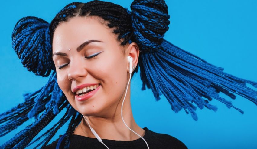 A young woman with blue dreadlocks listening to music.