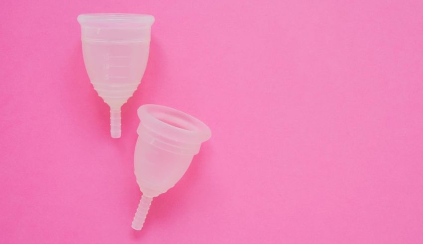 Two plastic syringes on a pink background.