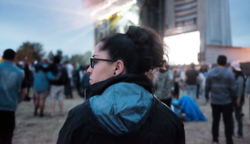 A woman is standing in front of a crowd at a music festival.