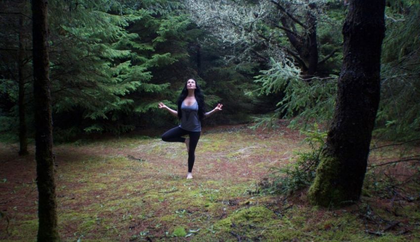 A woman doing yoga in the woods.