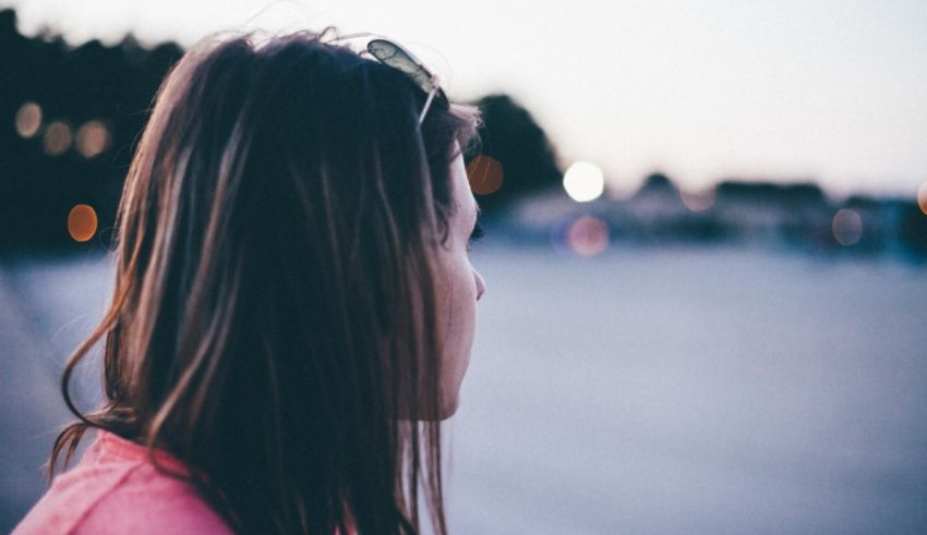 A woman looking at the city at dusk.