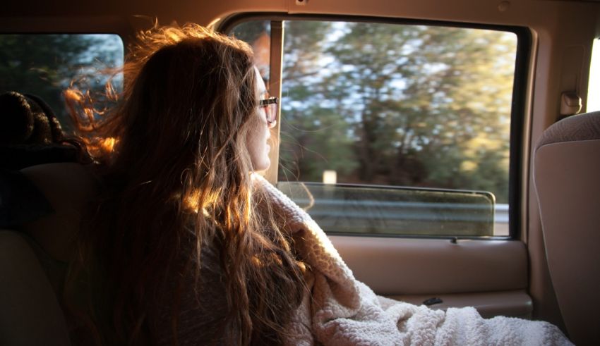 A woman sitting in the back seat of a car.