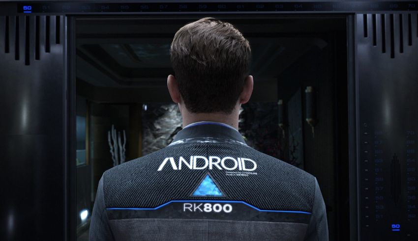 A man in a blue jacket is standing in front of a door.