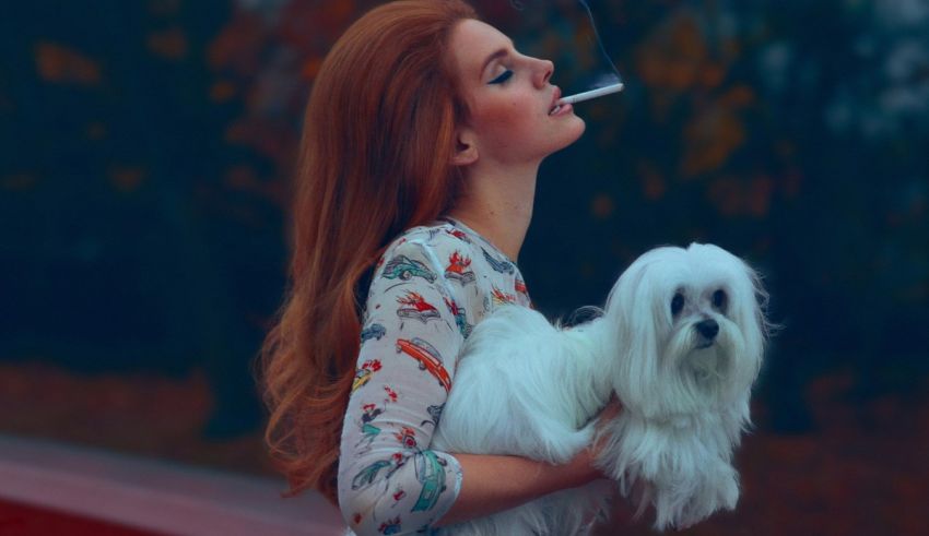 A woman smoking a cigarette while holding a white dog.