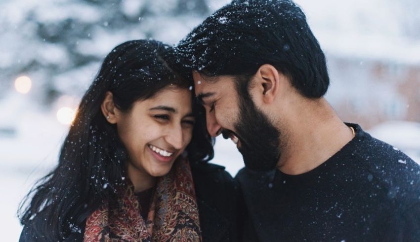 A man and a woman smiling in the snow.