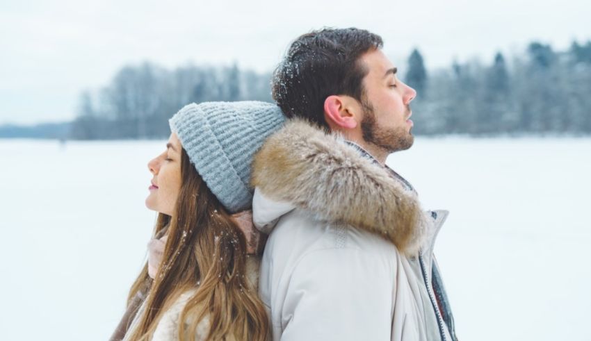 A man and woman standing in the snow.