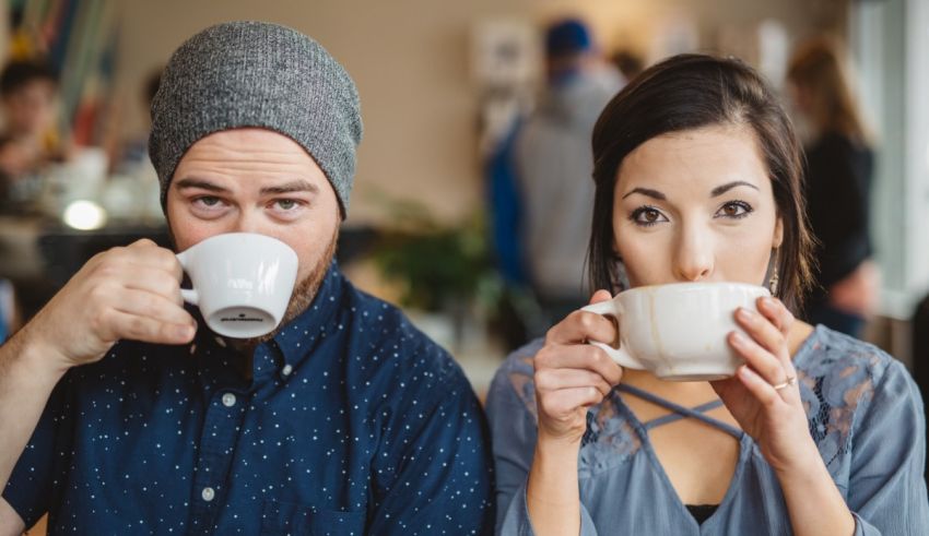 A man and woman drinking coffee in a cafe.