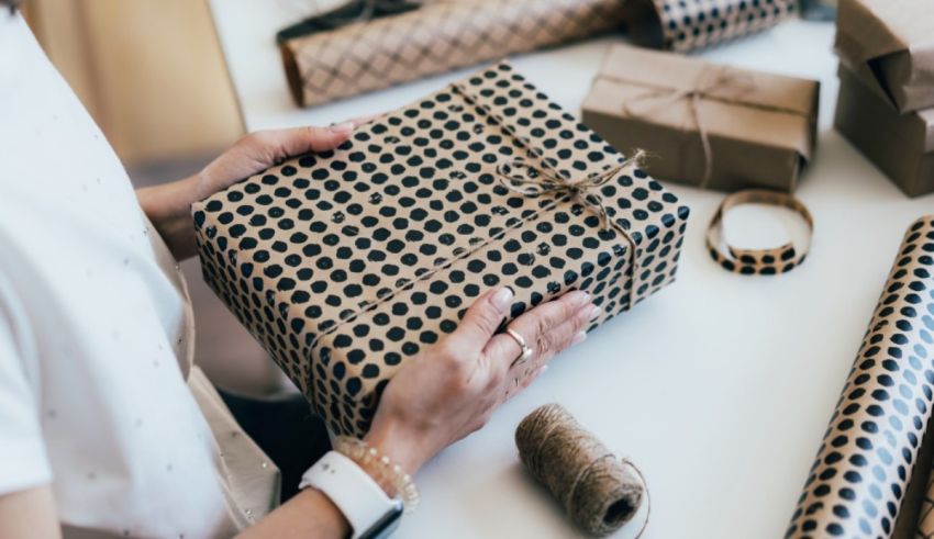 A woman is holding a gift wrapped in brown paper.