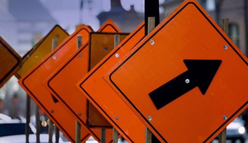 A row of orange construction signs on a street.