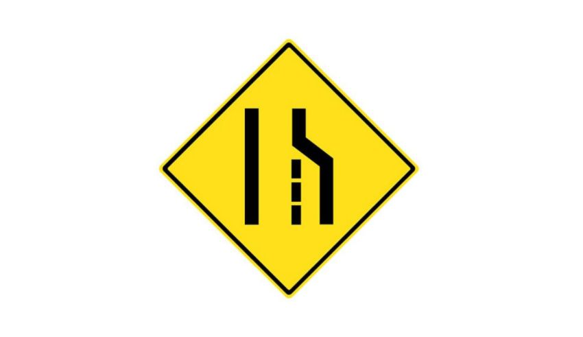 A yellow and black road sign with a triangle in the middle.