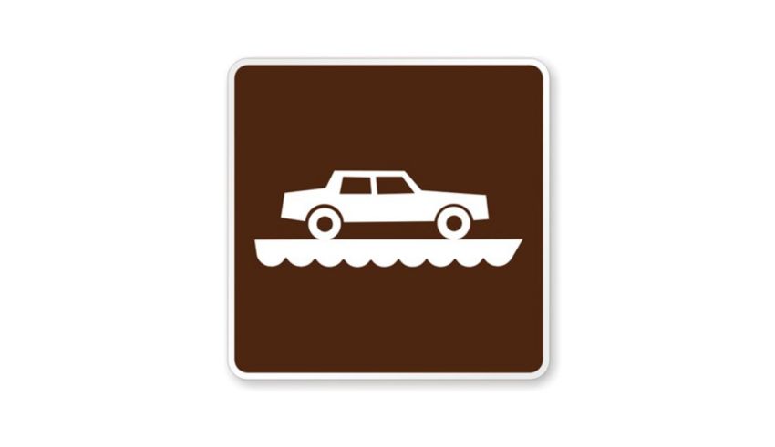 A brown and white sign with a car on it.