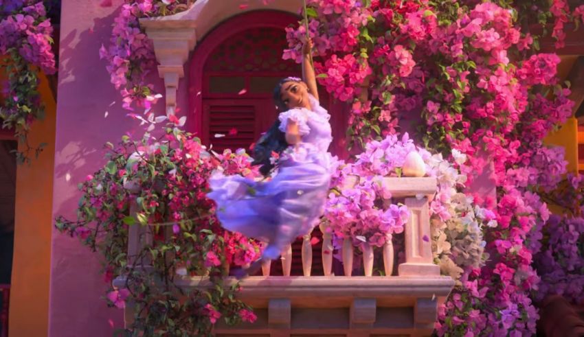 A woman in a pink dress is sitting on a balcony with flowers.