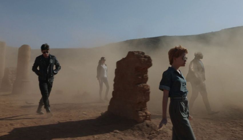 A group of people standing in a dusty area.