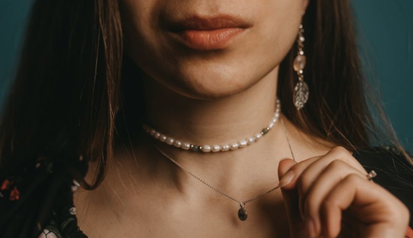 A woman wearing a necklace with pearls.