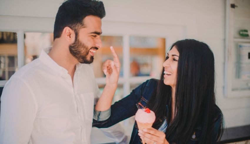A man and woman sharing an ice cream cone.