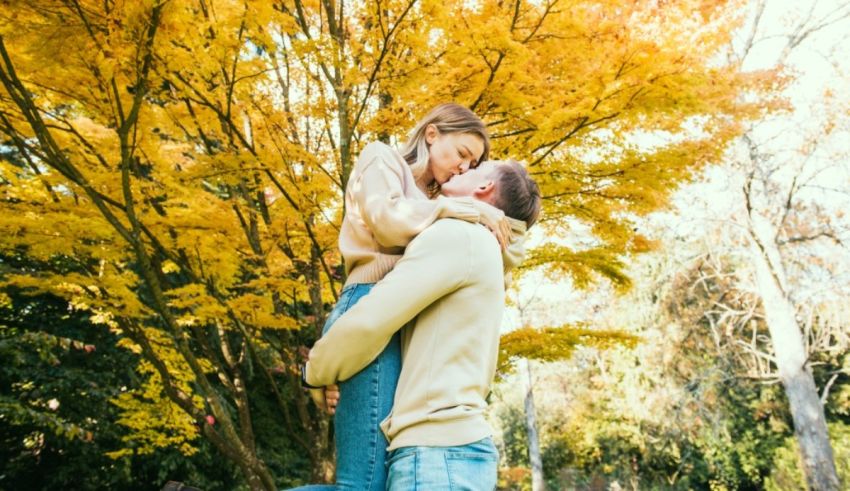 A couple hugging in the park in autumn.