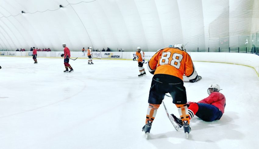 A group of hockey players playing in an ice rink.