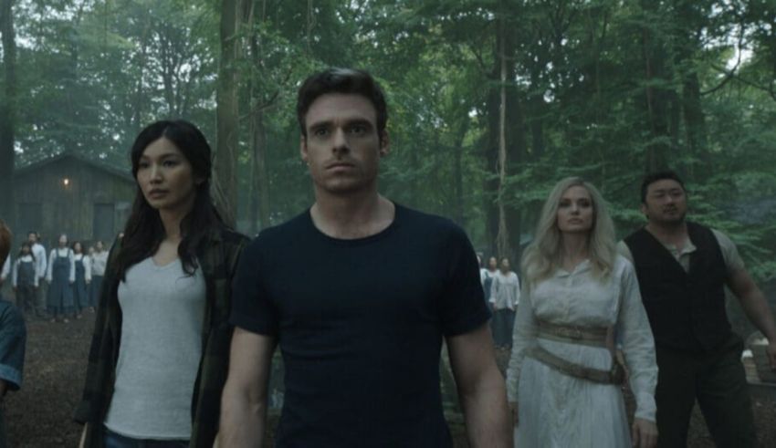 A group of people standing in a wooded area.