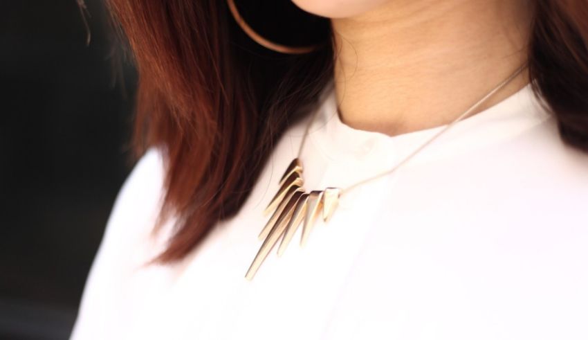 A woman wearing a necklace with spikes on it.