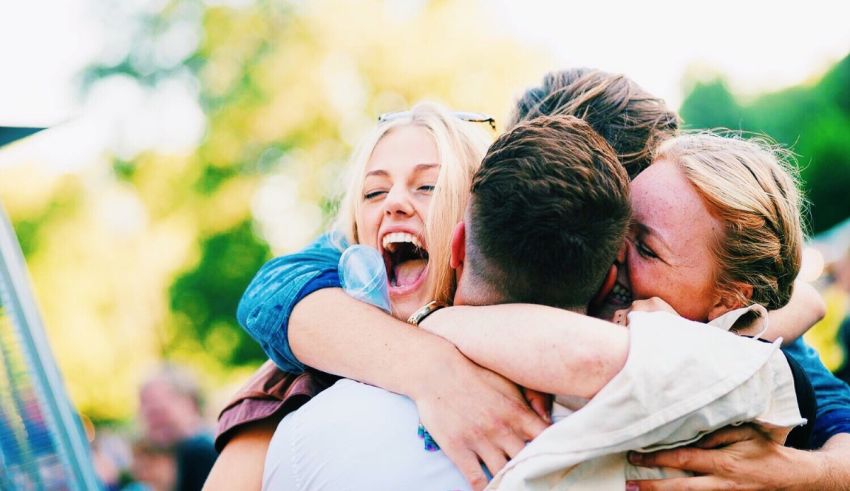 A group of people hugging each other at an outdoor event.