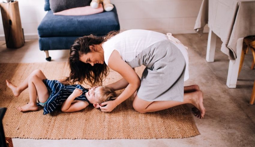 A mother and child playing on the floor in a living room.