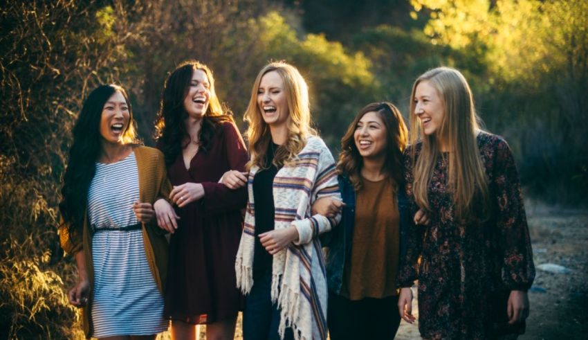 A group of women laughing while walking down a dirt road.