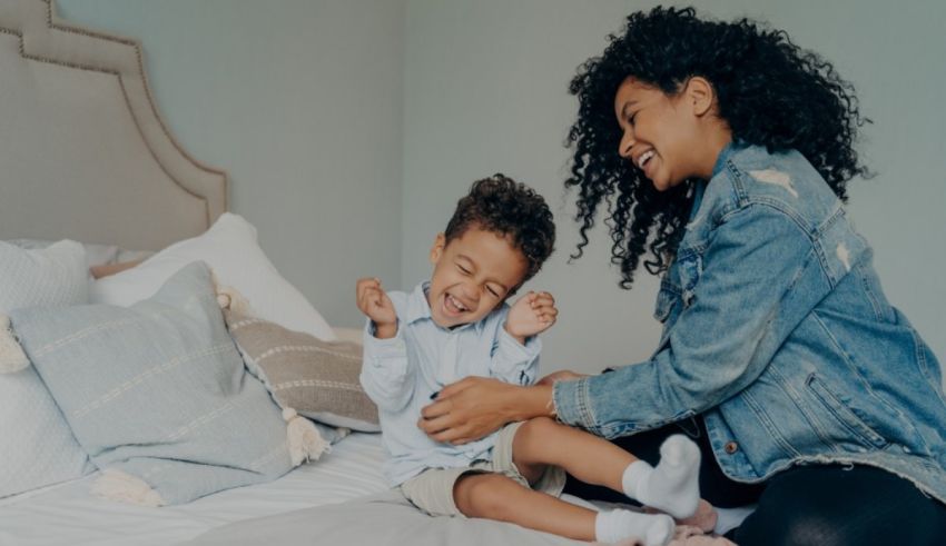 A woman and her son sitting on a bed.