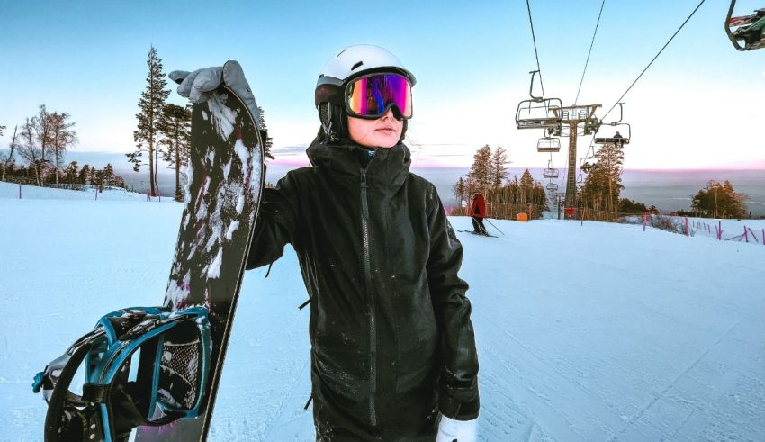 A woman holding a snowboard in front of a ski lift.