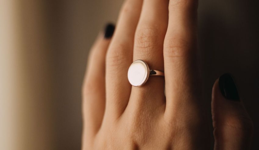 A woman's hand with a white ring on it.