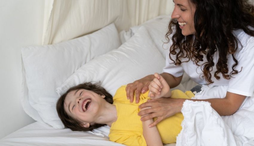 A woman laughing with a young boy in bed.