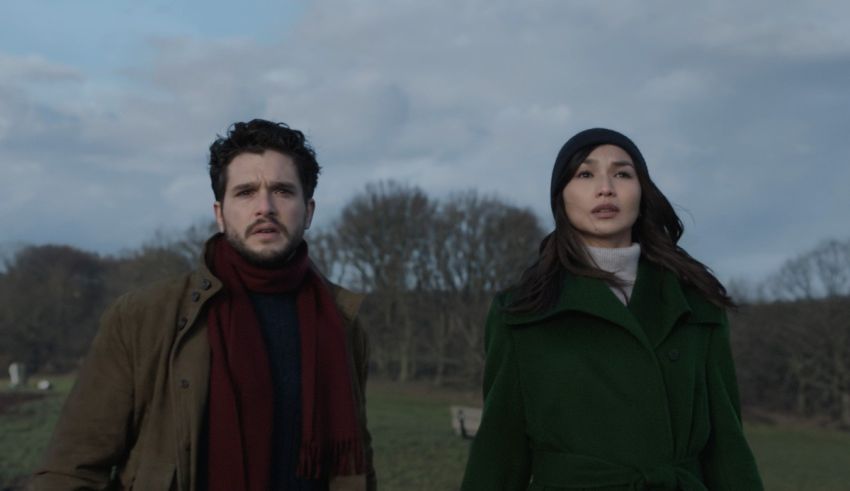 A man and woman standing next to each other in a field.