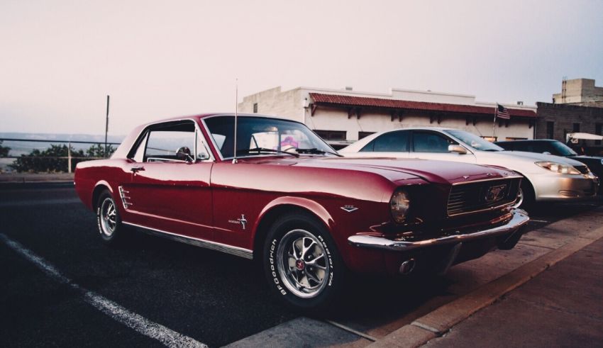 A red ford mustang parked on the side of the road.
