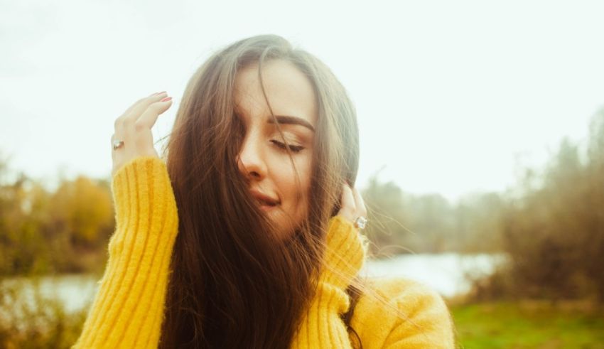 A young woman with long hair in a yellow sweater.