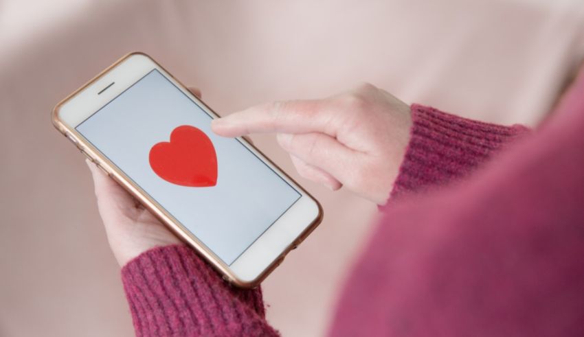 A woman holding a smartphone with a red heart on it.