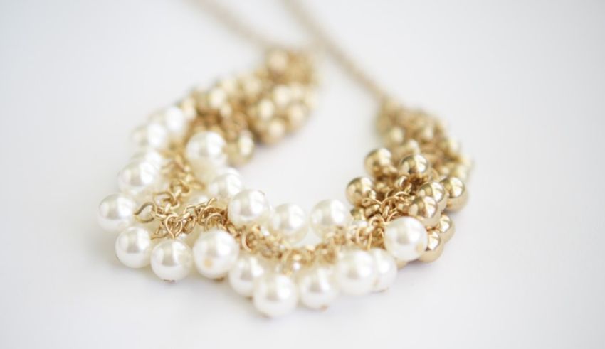 A necklace with white pearls and gold chains.