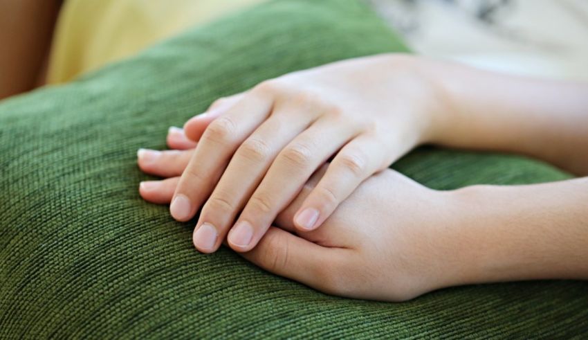 A woman's hand resting on a green pillow.