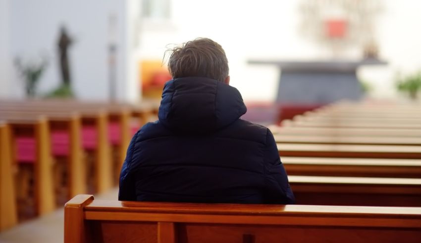 A man sitting in a pew in a church.
