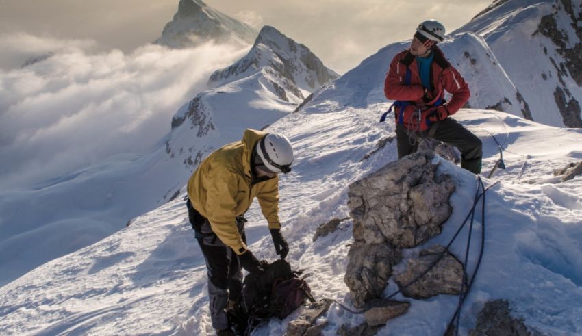 Two people standing on top of a snowy mountain.