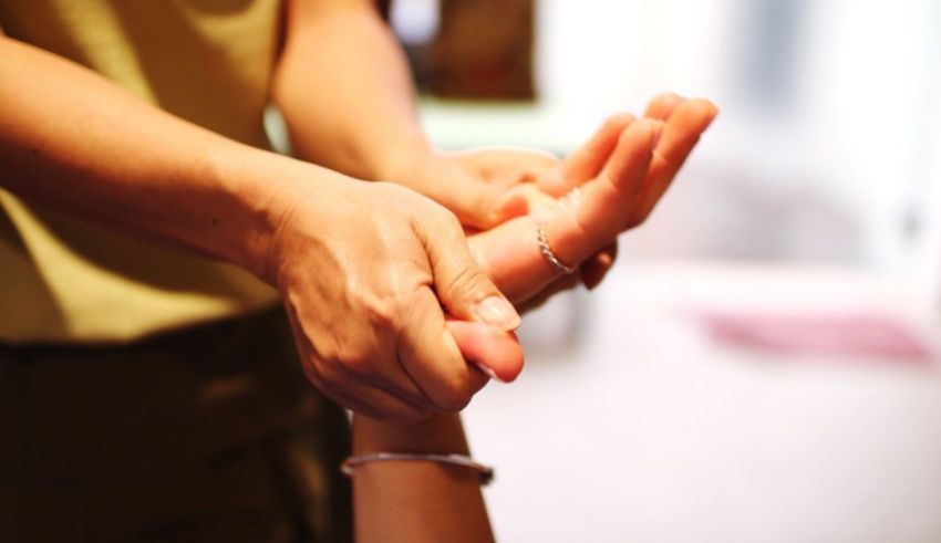 A person's hand being massaged by another person.