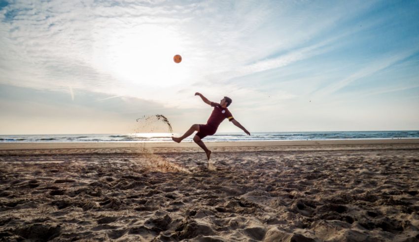 A man catching a frisbee on the beach.