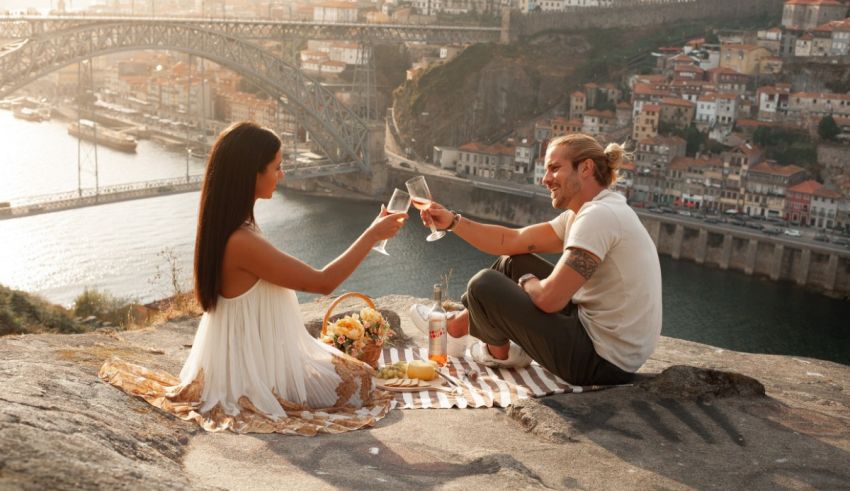 A couple enjoying a picnic on top of a hill overlooking the city of porto.