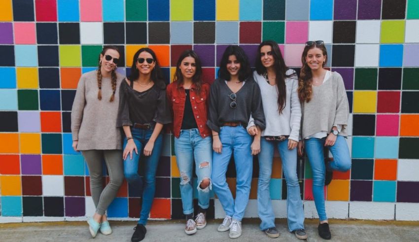 A group of women posing in front of a colorful wall.
