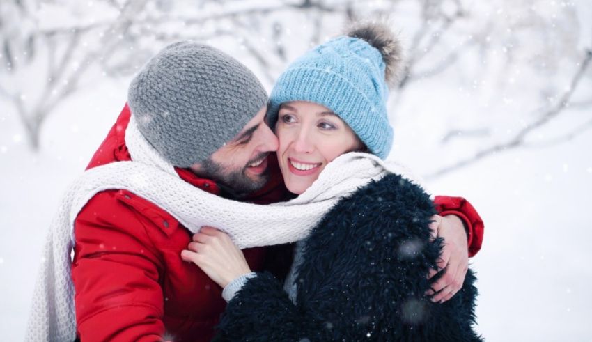 A man and woman hugging in the snow.