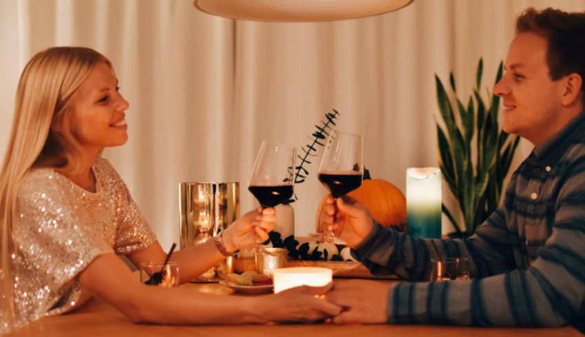 A man and woman holding wine glasses at a table.