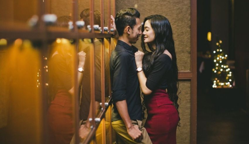 A couple is posing in front of a mirror.