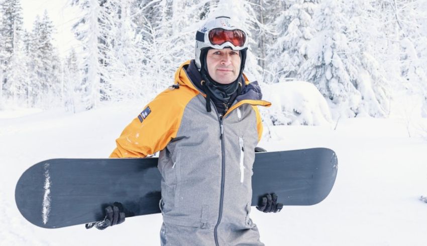 A man holding a snowboard in the snow.