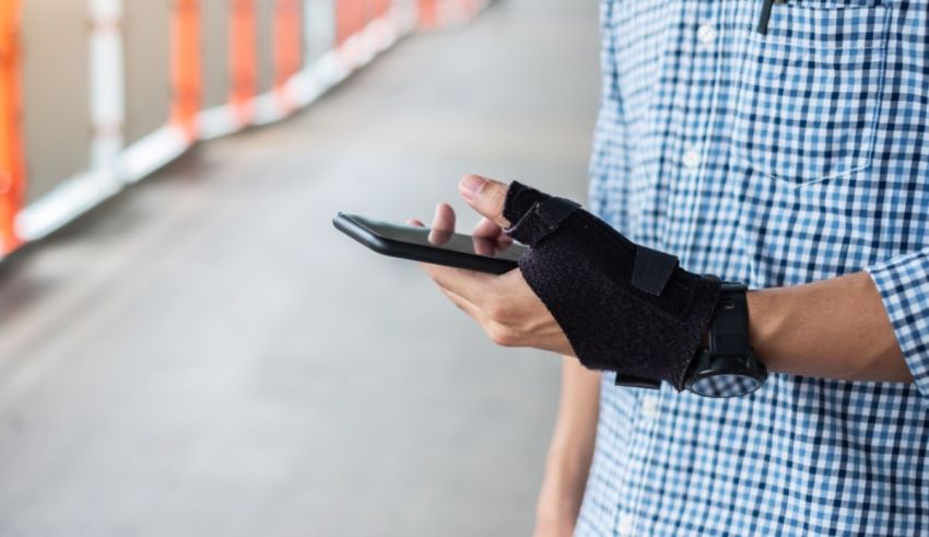 A man wearing a wrist brace holding a cell phone.