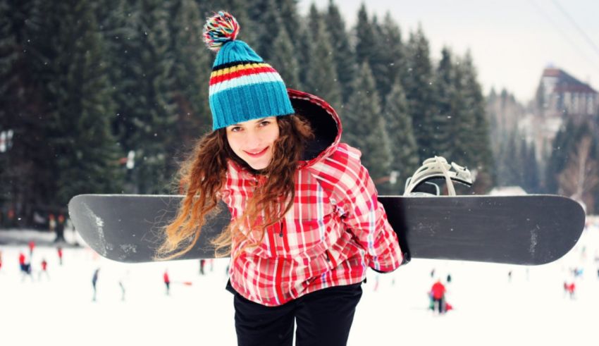 A girl holding a snowboard.