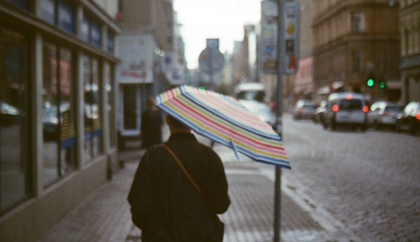 A person walking down a street with an umbrella.