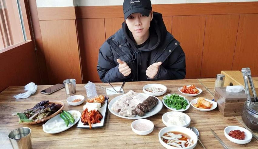 A man sitting at a table with a lot of food on it.